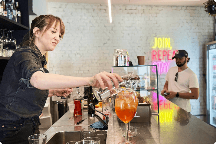 A bartender pouring a drink at the WAO bar counter