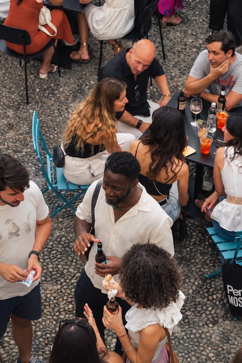 Aperitivo nel cortile di WAO visto dall'alto, con tavolini e persone sedute