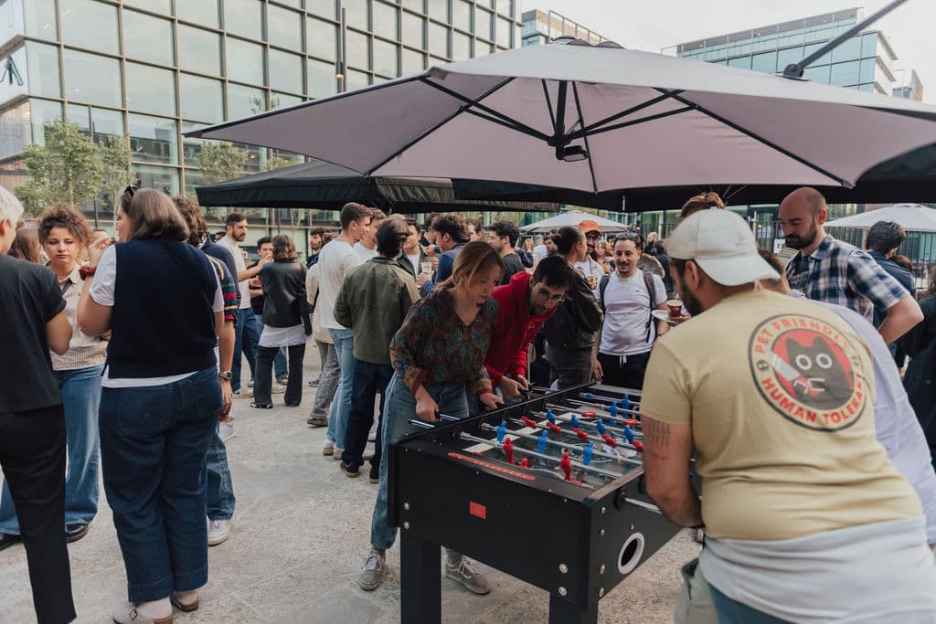 People around a foosball table in the WAO courtyard during an outdoor event