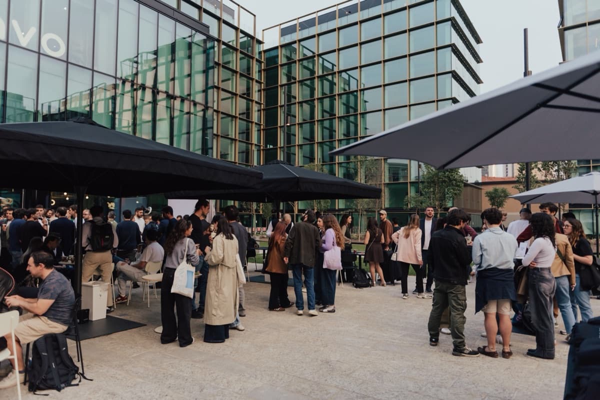 WAO Kitchen's busy terrace at sunset, with parasols and guests standing around