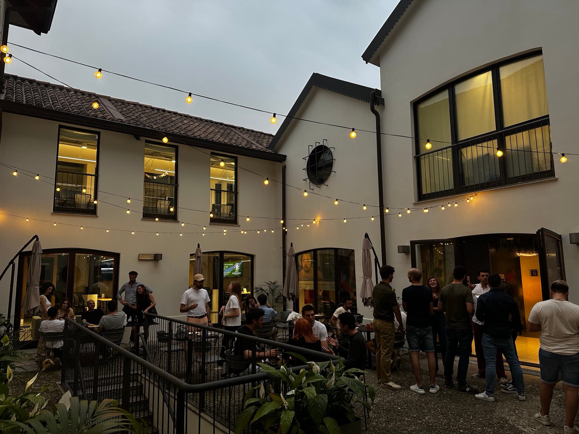 La corte di WAO Isola di sera, con le luci accese e un aperitivo in corso